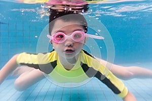Asian Chinese little boy swimming underwater
