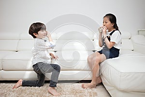 Asian Chinese little brother and sister playing tin can phone