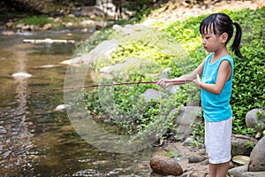 Asian Chinese little girl angling with fishing rod