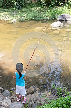 Asian Chinese little girl angling with fishing rod