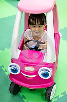 Asian Chinese little girl driving toy car