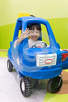 Asian Chinese little girl driving toy car