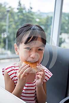 Asian Chinese little girl eating bread