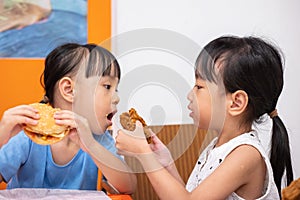 Asian Chinese little girl eating burger and fried chicken