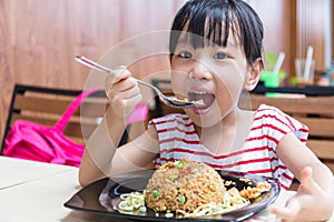 Asian Chinese little girl eating fried rice
