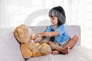 Asian Chinese little girl examination teddy bear with stethoscope