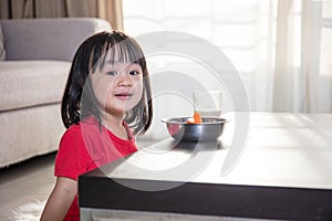 Asian Chinese little girl having breakfast with milk