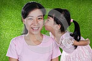 Asian Chinese little girl kissing her mother