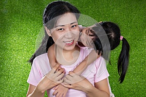 Asian Chinese little girl kissing her mother