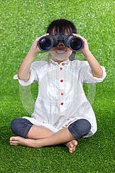 Asian Chinese little girl looking through binoculars