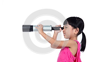 Asian Chinese little girl looking through a telescope