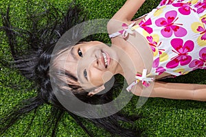 Asian Chinese little girl lying on the grass