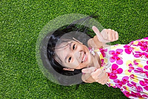 Asian Chinese little girl lying on the grass