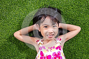 Asian Chinese little girl lying on the grass