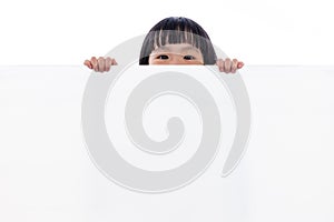 Asian Chinese little girl peeping behind white board