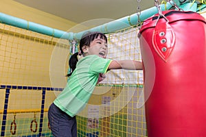 Asian Chinese little girl playing with punching bag