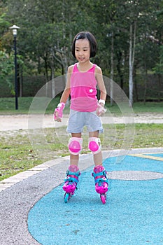 Asian Chinese little girl playing with roller skates