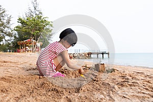 Asian Chinese little girl playing sand at beach