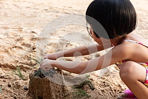 Asian Chinese little girl playing sand at beach