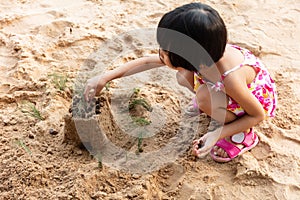 Asian Chinese little girl playing sand at beach