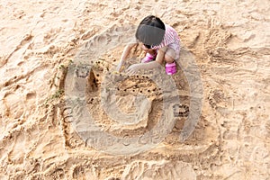 Asian Chinese little girl playing sand at beach