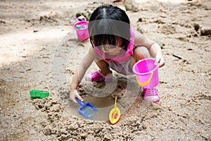 Asian Chinese little girl playing sand at creek
