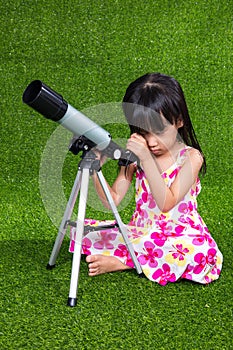 Asian Chinese little girl playing with a telescope