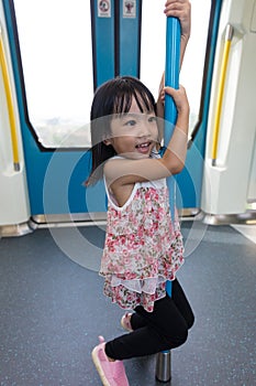 Asian Chinese little girl pole dancing inside a MRT transit