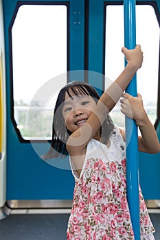 Asian Chinese little girl pole dancing inside a MRT transit