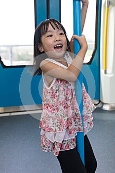 Asian Chinese little girl pole dancing inside a MRT transit