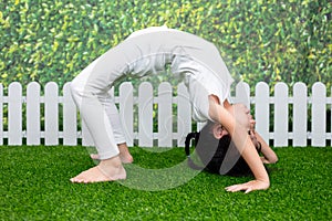 Asian Chinese little girl practicing yoga pose on a mat