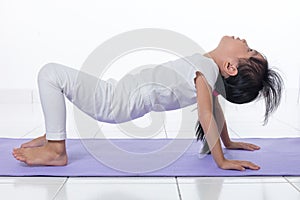 Asian Chinese little girl practicing yoga pose