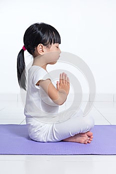 Asian Chinese little girl practicing yoga pose