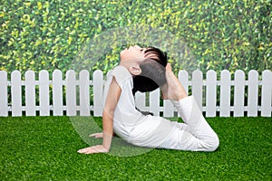 Asian Chinese little girl practicing yoga pose on a mat