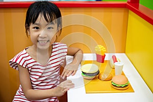 Asian Chinese little girl role-playing at burger store