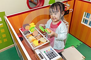 Asian Chinese little girl role-playing at burger store photo