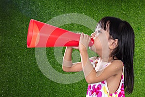 Asian Chinese little girl shouting through megaphone