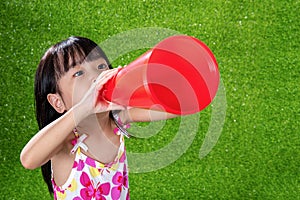 Asian Chinese little girl shouting through megaphone