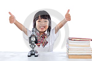 Asian Chinese little girl showing thumbs up with microscope