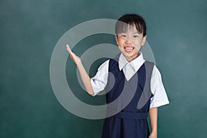 Asian Chinese little girl standing in front of green blackboard