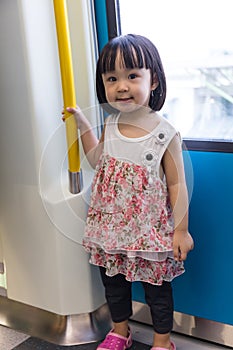Asian Chinese little girl standing inside a MRT transit