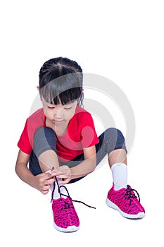 Asian Chinese little girl tying her shoes