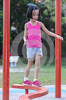 Asian Chinese little girl walking on the balance beam