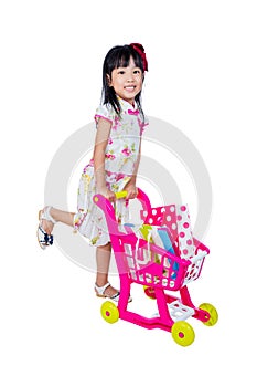 Asian Chinese little girl wearing cheongsam pushing toy trolley