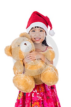 Asian Chinese little girl wearing santa hat holding teddy bear