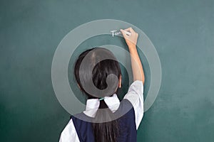 Asian Chinese little girl writing on blackboard