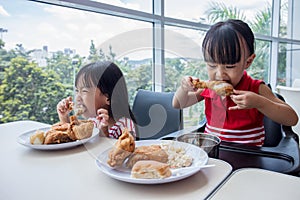 Asian Chinese little girls eating fried chicken