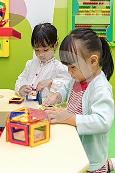 Asian Chinese little girls playing colorful magnet plastic block