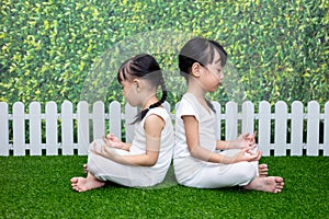 Asian Chinese little girls practicing yoga pose on a mat