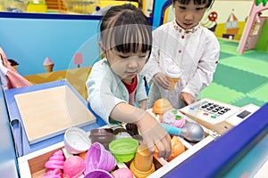 Asian Chinese little girls role-playing at ice cream store